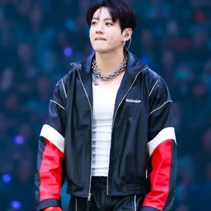 Jungkook wearing a black jacket with red and white sleeves during a BTS performance.