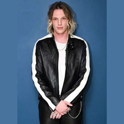 Jamie Campbell wearing a black leather jacket with white sleeve stripes and an erect collar.