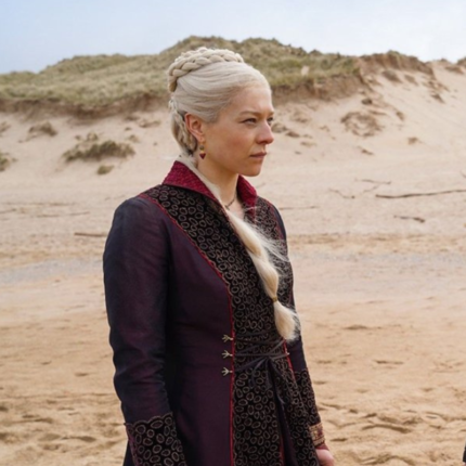 Rhaenyra Targaryen wearing a purple House of the Dragon coat.