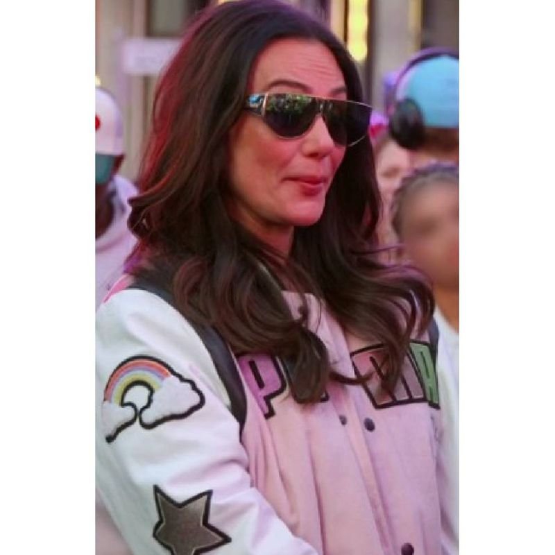 Jersey-Shore-Family-Vacation-S09-Jenni-Farley-Pink-Varsity-Jacket-5 Woman wearing a pink and white varsity jacket with colorful lettering and rainbow cloud sleeve artwork.