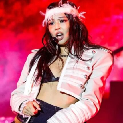 Front view of the Jennie 2026 Lollapalooza Jacket in oyster white with a cropped military-inspired silhouette, stand-up collar, decorative buttons, and shoulder epaulettes.