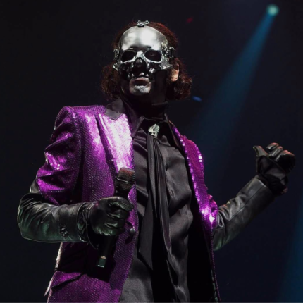 Papa Emeritus wearing a purple sequin coat during a concert