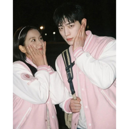 Couple wearing matching pink and white varsity jackets with H chest patches and striped collars.