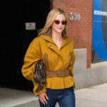 Lili Reinhart wearing a mustard-yellow The Love Hypothesis jacket with a belted waist, ribbed collar, and balloon sleeves.