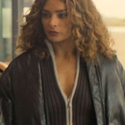 Woman wearing a dark oversized jacket over a ribbed zip-front top, featuring a relaxed fit and a layered streetwear look.