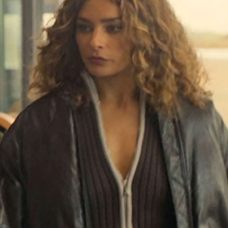 Charlie-Chan-Dagelet-The-Perfect-Lie-S01-Black-Bomber-Leather-Jacket Woman wearing a dark oversized jacket over a ribbed zip-front top, featuring a relaxed fit and a layered streetwear look.