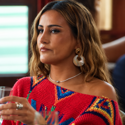 Zeyno Taylan wearing a red multicolor patterned knitted poncho with an asymmetrical neckline on Made in Chelsea.